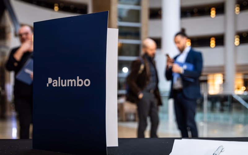 Carpeta de Palumbo Consulting en la mesa de un evento en Granada